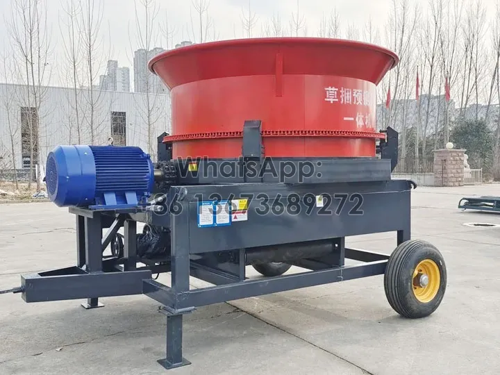 Round bale hay grinder with lower outlet